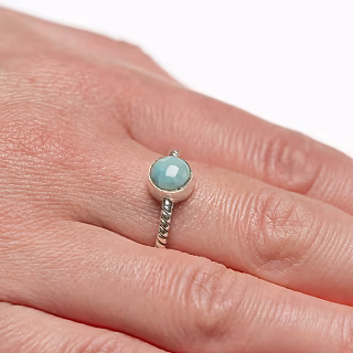 A tiny silver ring with a larimar